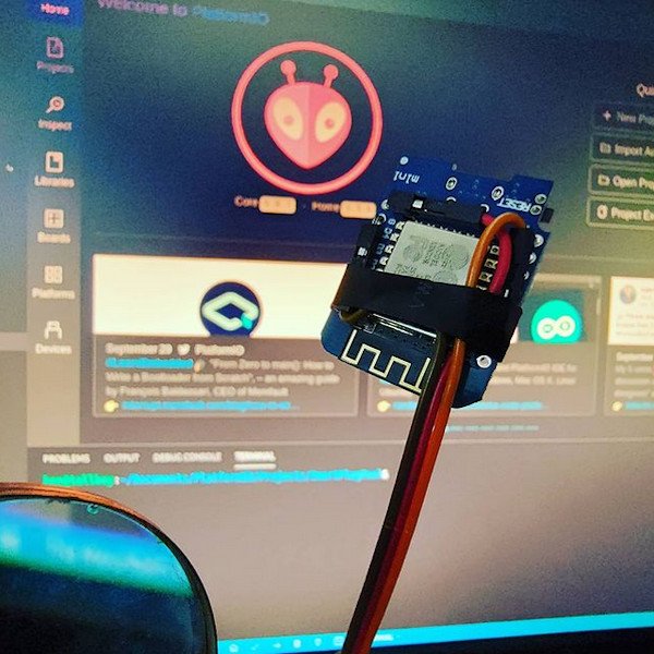 WeMos D1 mini with wires attached. platformio on screen in background