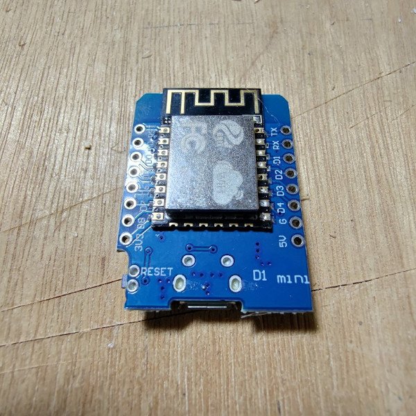 ESP8266 LOLIN WeMos D1 Mini without headers sitting on a wooden table